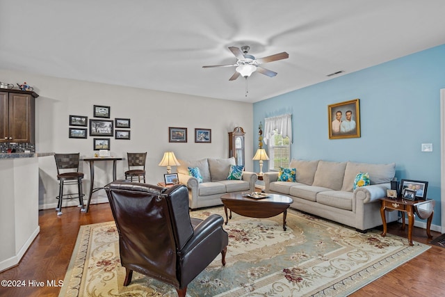 living room featuring ceiling fan and dark wood-type flooring