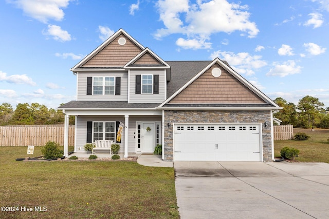 craftsman house featuring a front lawn, covered porch, and a garage