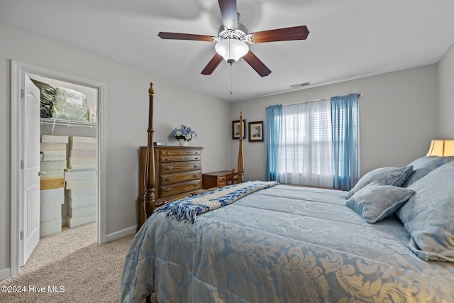 carpeted bedroom featuring a walk in closet, a closet, and ceiling fan