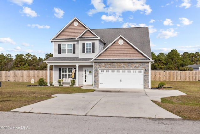 view of front of property with covered porch, a garage, and a front yard