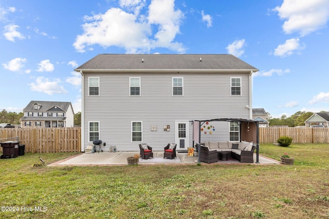 rear view of house with a lawn, an outdoor living space, and a patio