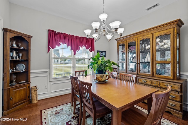 dining area featuring dark hardwood / wood-style flooring and an inviting chandelier