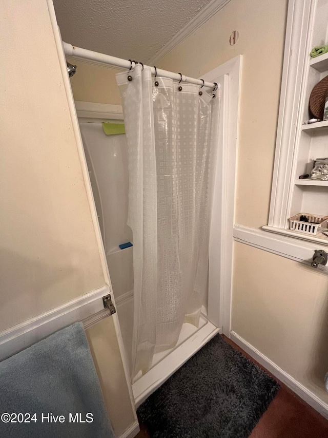 bathroom with a shower with curtain, ornamental molding, and a textured ceiling