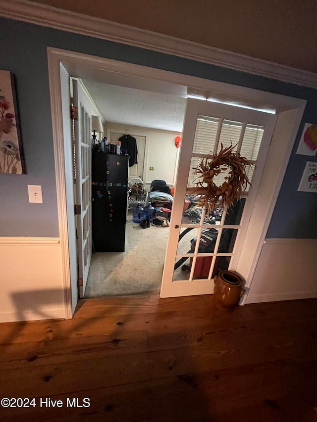 hall with wood-type flooring and crown molding