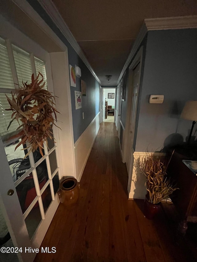 hallway with dark hardwood / wood-style floors and ornamental molding