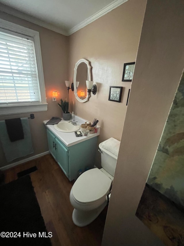 bathroom featuring toilet, vanity, ornamental molding, and hardwood / wood-style flooring