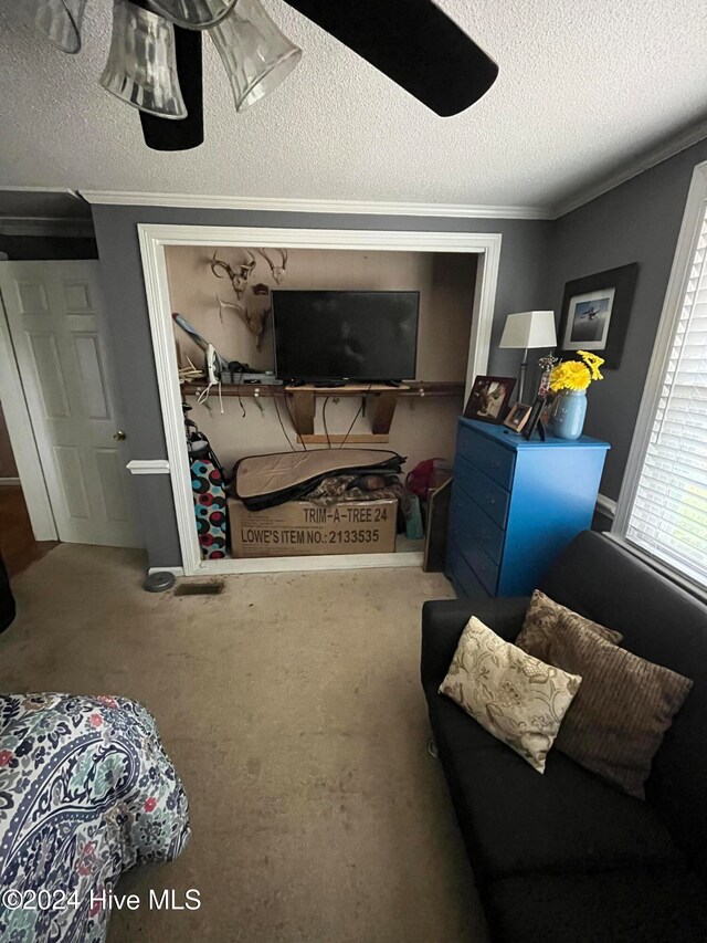 carpeted bedroom with a textured ceiling and crown molding