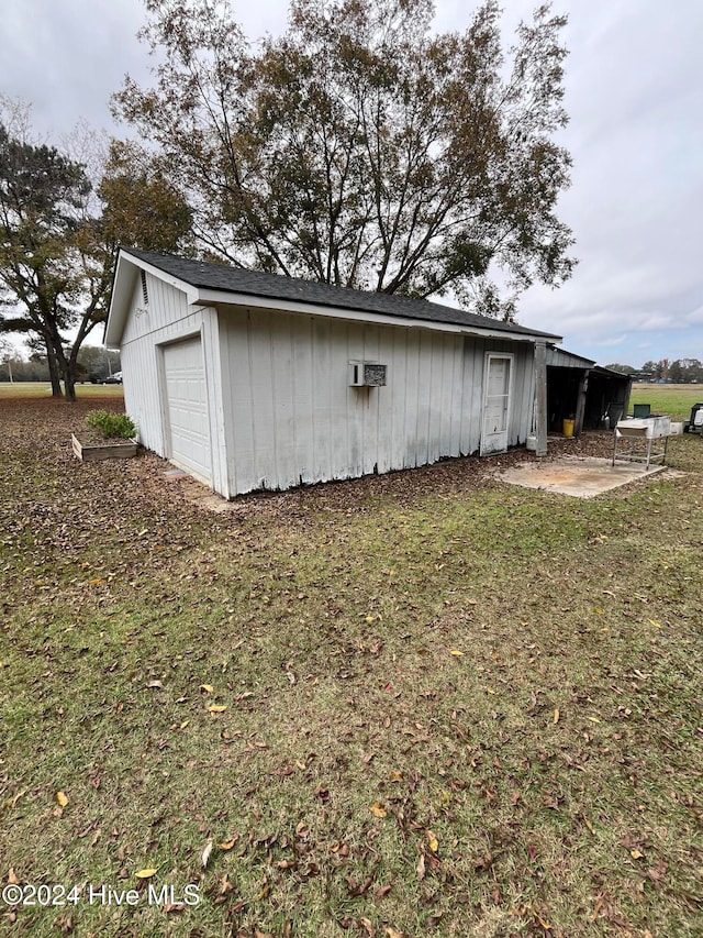 view of side of home with a garage and an outbuilding