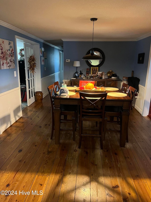 dining space featuring crown molding and dark wood-type flooring