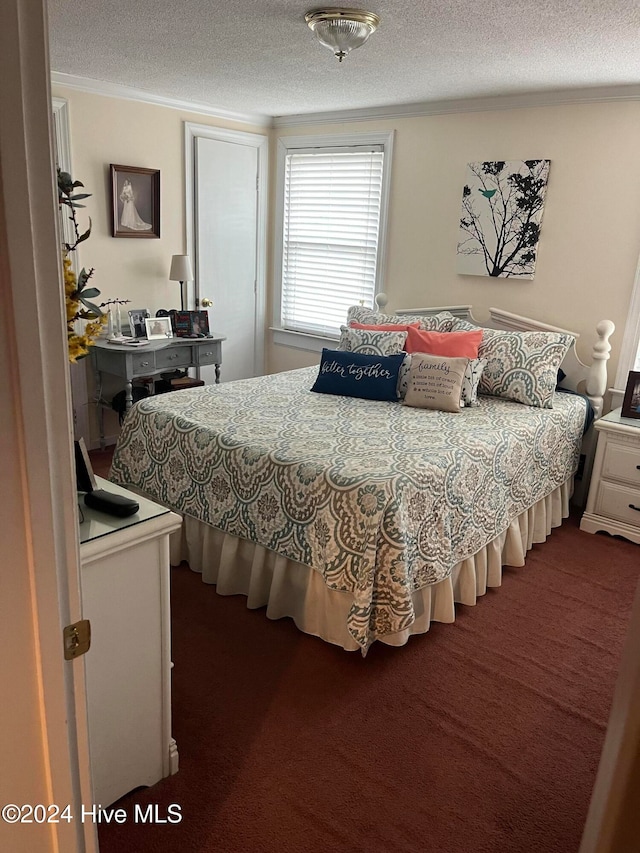 bedroom with dark colored carpet and a textured ceiling