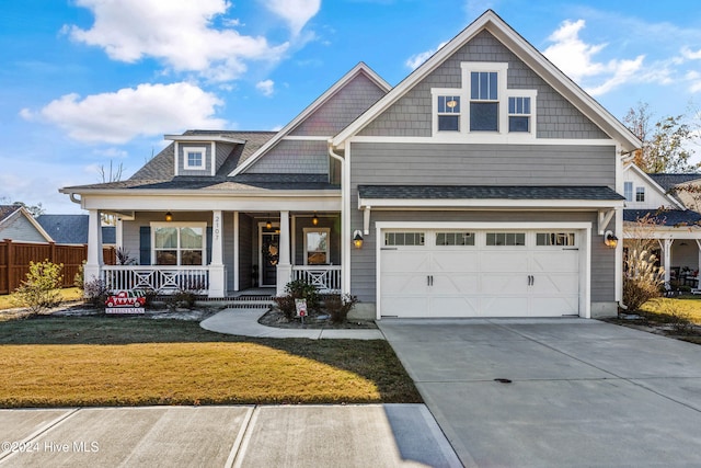 craftsman house with a garage, a front lawn, and a porch