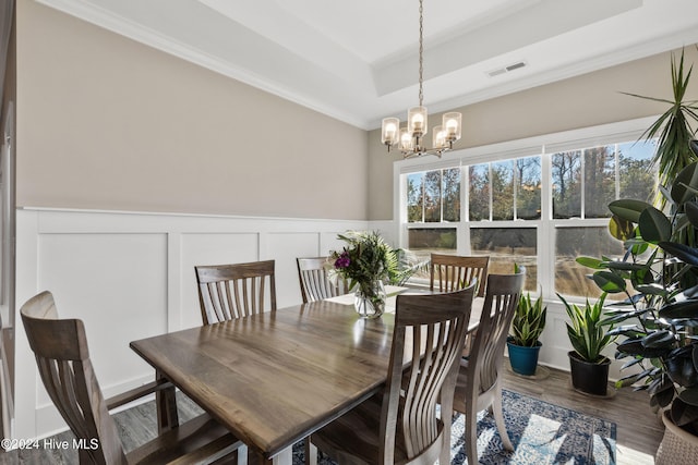 dining space featuring a chandelier, crown molding, hardwood / wood-style floors, and a tray ceiling