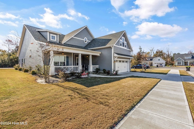 view of front of house featuring a front yard, a garage, and a porch