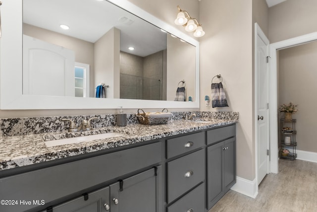 bathroom with vanity, a tile shower, and hardwood / wood-style flooring