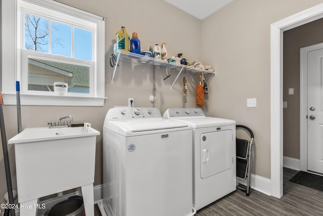 washroom featuring dark wood-type flooring, washer and clothes dryer, and sink