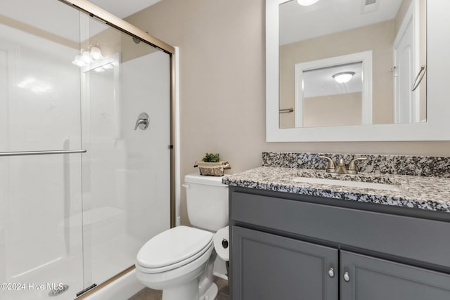 bathroom with toilet, a shower with door, and vanity