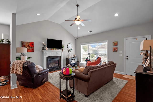 living room featuring ceiling fan, lofted ceiling, and light hardwood / wood-style floors