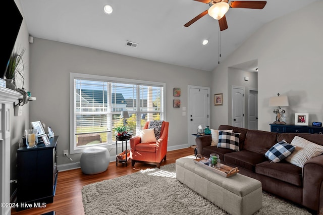 living room with ceiling fan, hardwood / wood-style floors, and vaulted ceiling