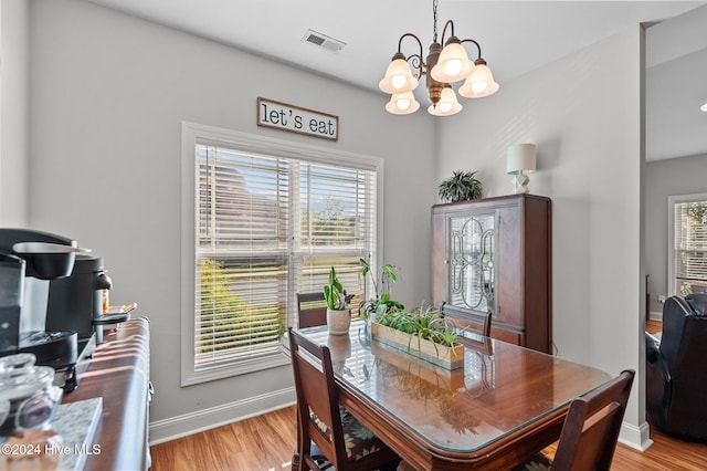 dining space with a chandelier and light wood-type flooring