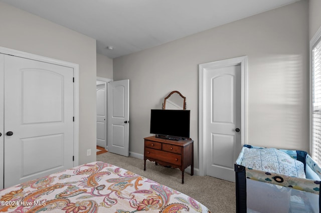 bedroom featuring light carpet and a closet