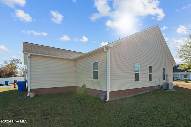 view of home's exterior with central AC and a yard