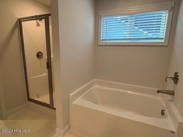 bathroom featuring shower with separate bathtub and a healthy amount of sunlight