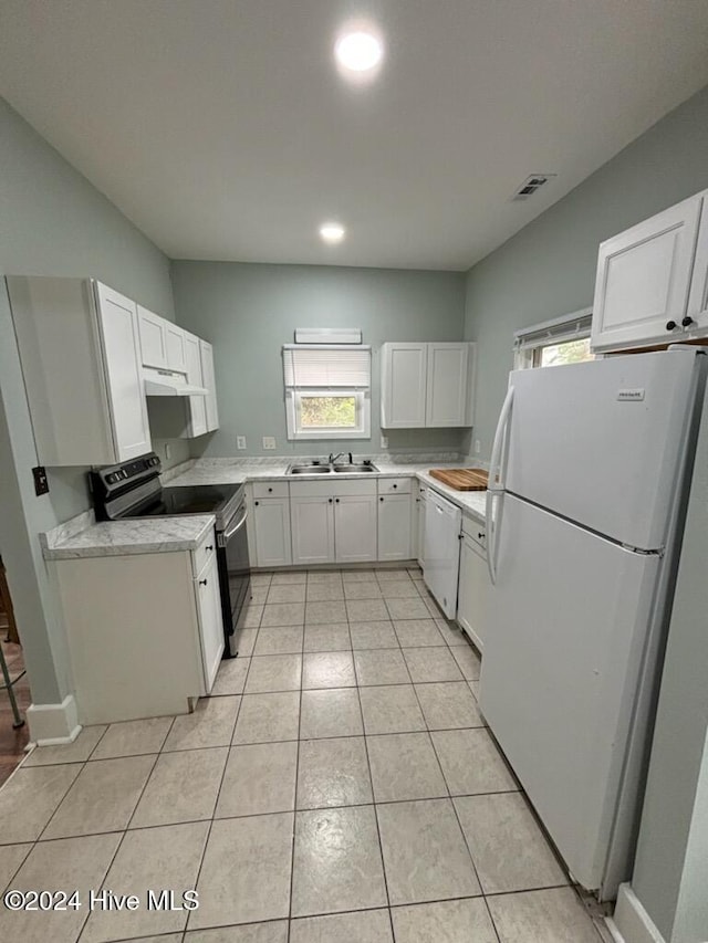 kitchen featuring white cabinets, sink, white appliances, and light tile patterned flooring