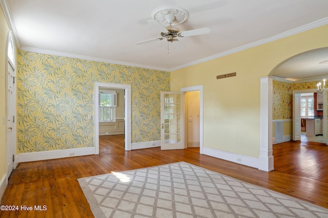 spare room featuring ceiling fan with notable chandelier, hardwood / wood-style flooring, and crown molding