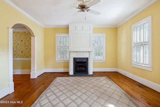 unfurnished living room with ceiling fan, a wealth of natural light, hardwood / wood-style flooring, and ornamental molding