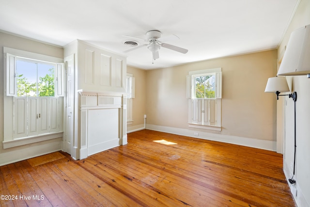 unfurnished living room with hardwood / wood-style floors, ceiling fan, and ornamental molding