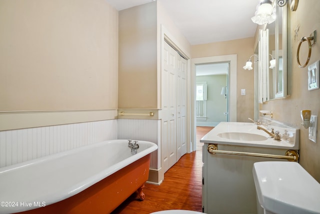 bathroom with a washtub, vanity, and hardwood / wood-style flooring