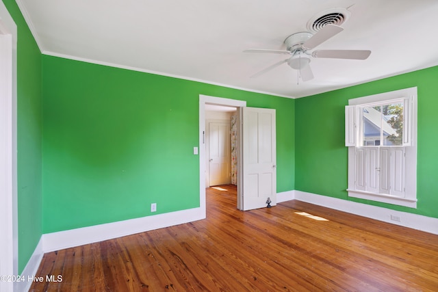 unfurnished bedroom with ceiling fan, hardwood / wood-style floors, and ornamental molding