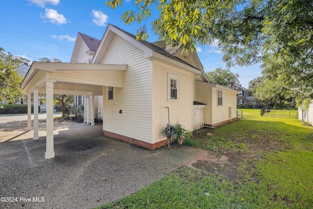 view of home's exterior featuring a carport and a yard