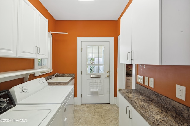 laundry area with washing machine and clothes dryer, cabinets, and sink