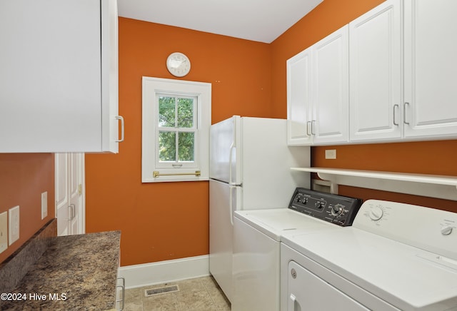 washroom with washing machine and clothes dryer and cabinets