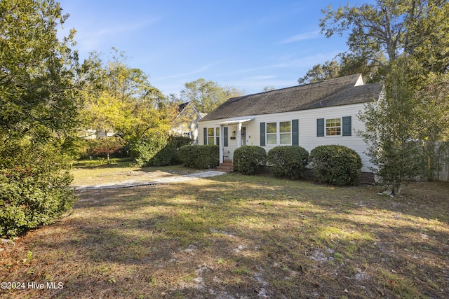view of front of home featuring a front lawn and roof with shingles