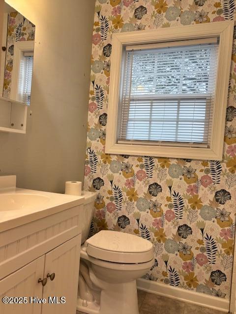 bathroom with wallpapered walls, tile patterned floors, vanity, and toilet