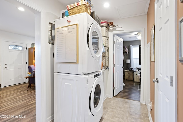 laundry area with light wood finished floors, stacked washer / dryer, attic access, laundry area, and recessed lighting