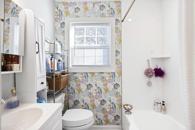 bathroom with toilet, wallpapered walls, vanity, and  shower combination