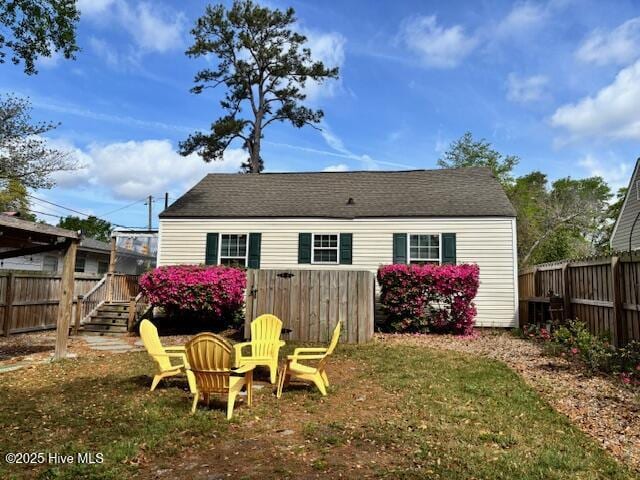 rear view of property with a lawn and a fenced backyard