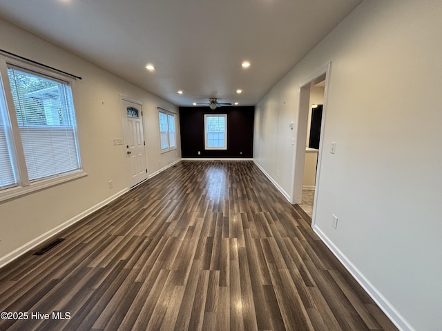 unfurnished living room with a ceiling fan, baseboards, dark wood-type flooring, visible vents, and recessed lighting