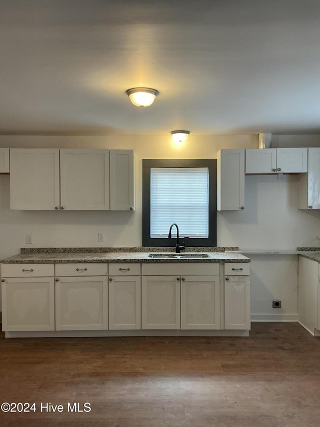 kitchen with light hardwood / wood-style flooring, white cabinetry, and sink