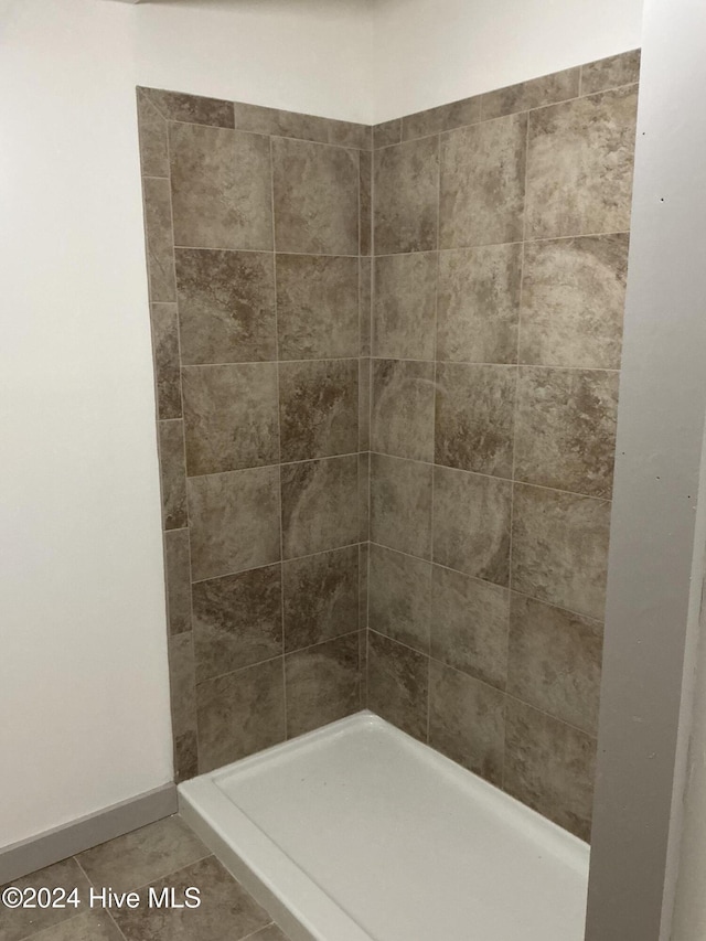 bathroom with tile patterned flooring and walk in shower