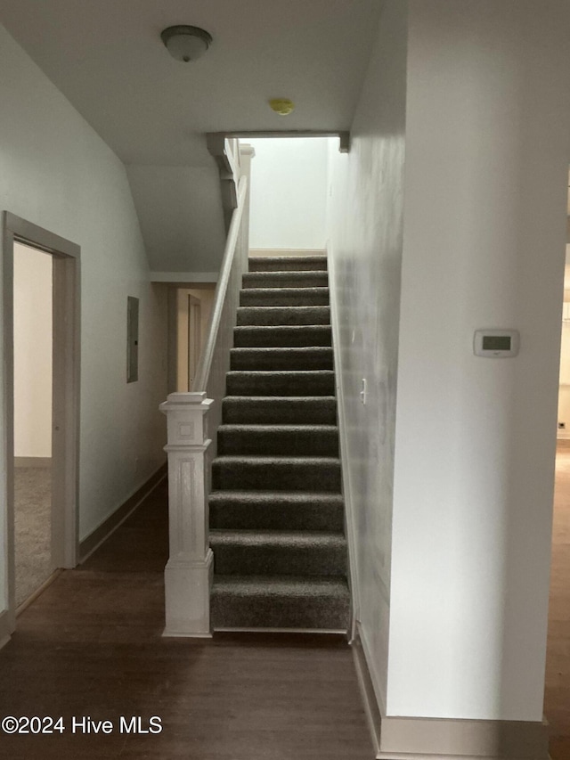 staircase featuring hardwood / wood-style floors and electric panel