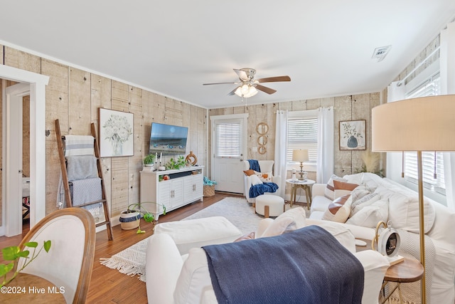 living room with wood-type flooring, ceiling fan, and plenty of natural light