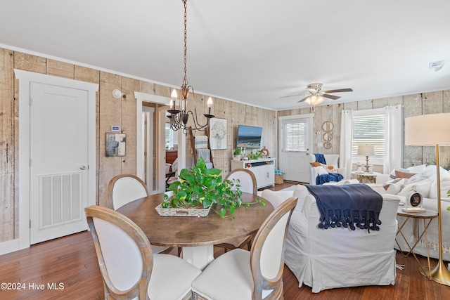 dining room with ceiling fan with notable chandelier and dark wood-type flooring