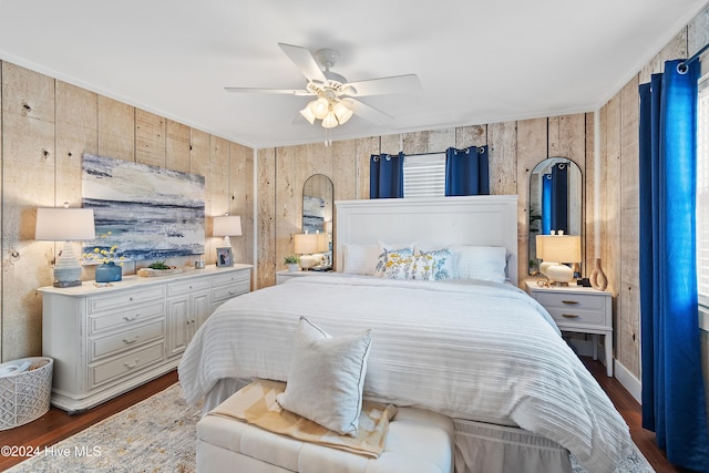 bedroom featuring wood walls, ceiling fan, and dark hardwood / wood-style flooring