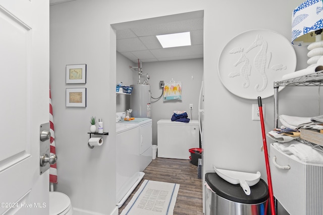 bathroom featuring water heater, washing machine and dryer, hardwood / wood-style floors, and a paneled ceiling