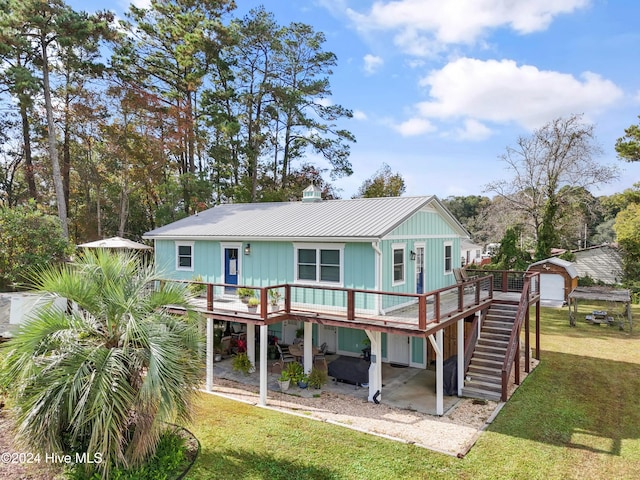 back of property with a garage, a wooden deck, and a yard