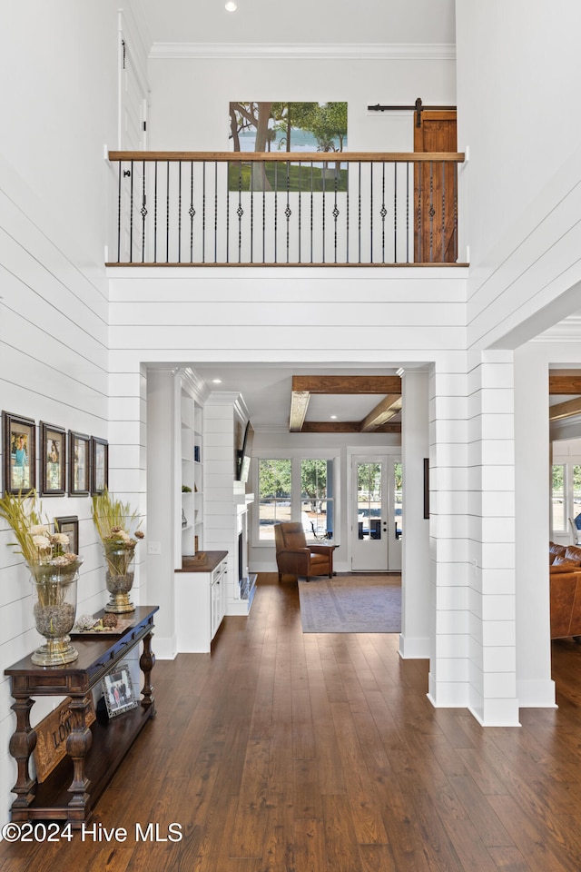 foyer with dark hardwood / wood-style flooring, a high ceiling, and ornamental molding